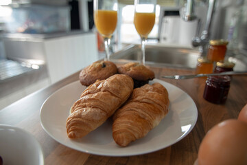 A celebration breakfast is served in this trendy renovated camper van, includes eggs, croissants, orange juice etc served on wooden kitchen surface and grey tiled kitchen area