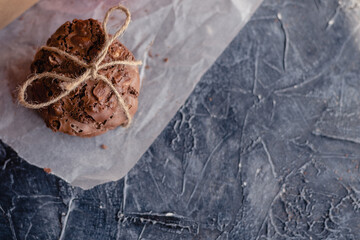Homemade chocolate chip cookies on red paper in a craft cardboard box on a dark background. DIY gift. Top view