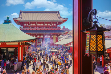 Colorful bronze lantern of Kannon hall ornate of manji buddhist swastika or sauwastika with crowds...