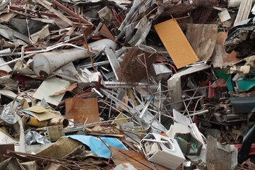 A pile of unnecessary metal things lying in a junkyard.