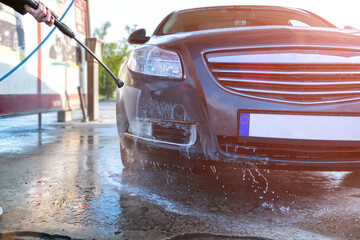 Water clean auto car on carwash hand service. Vehicle wash from soap, foam on cleaner station. Care with pressure wax.