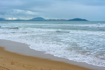 Cloudy day, sand deserted beach of the coast of Haitang Bay in South China Sea. Sanya, island Hainan, China. Nature Landscape.