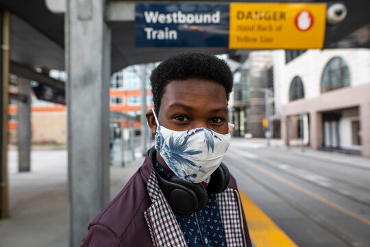 Portrait confident young man in face mask at city train station