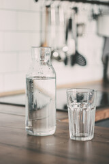 A carafe of water on the kitchen wooden table. Bottle of water. the concept of a healthy lifestyle