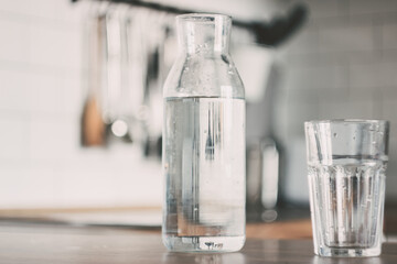 A carafe of water on the kitchen wooden table. Bottle of water. the concept of a healthy lifestyle