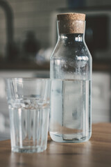A carafe of water on the kitchen wooden table. Bottle of water. the concept of a healthy lifestyle