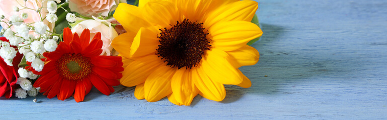 青色に塗られた木材背景の様々な花のブーケ