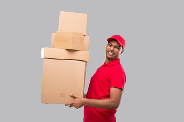 Delivery Man Holding a lot Carton Boxes Isolated. Indian Delivery Boy Overloaded with Boxes Smilling. Heavy Boxes