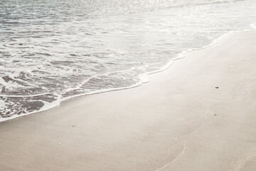 Ocean Wave on Sandy Beach Background