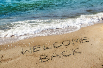 Words Welcome Back are written in the sand on the beach for the tourists, reopen after the coronavirus pandemic, sea holidays are possible again