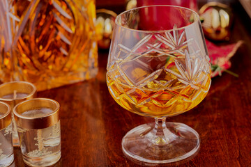 Crystal glass with whisky in i,t with a decanter in the background.