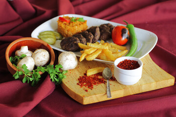Meat cutlets. Tomato bulgur pilaf. Roasted vegetables. French fries.