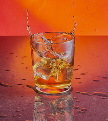 Whisky splash shot on a orange gradient backdrop.