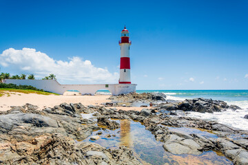 The lighthouse or beacon Itapuã Tip Itapuã is a lighthouse in Salvador, Bahia, Brazil. Is located on the beach Itapuã in Itapuã subdistrict, about 23 kilometers (14 mi) northeast are the Lighthouse Ba - obrazy, fototapety, plakaty