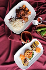 Beef with vegetables in soy sauce with cooked rice. A dish on a red background. A spicy dish of Japanese cuisine.