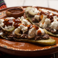 Mexican nopal cactus huaraches with cheese and beans on white background
