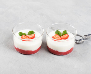 Cream berry dessert Panna cotta vanilla with strawberries in a glass Cup on a light gray background