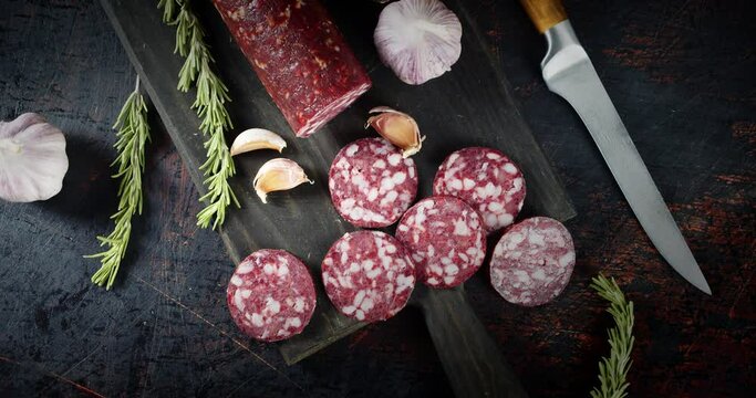 Pieces of salami with garlic and rosemary slowly rotate.