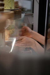 Girl takes cakes from a shop window in a restaurant or cafe.