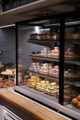 Showcase in a restaurant or cafe where delicious desserts with drinks are sold. Cakes and french macaroons.