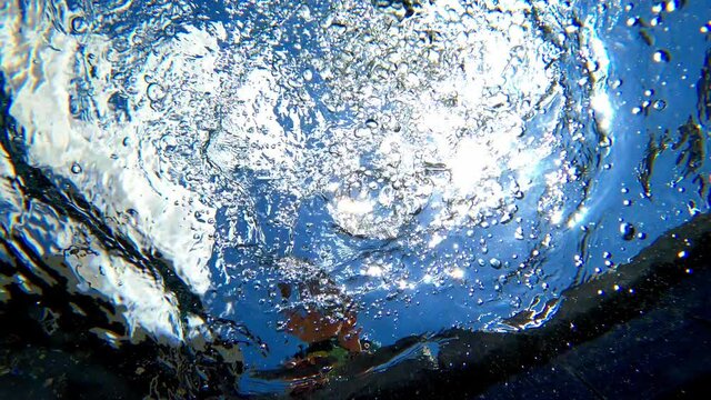 Bubbles Coming Up From Underwater In A Pool With A Small Buy Moving Hands In Water