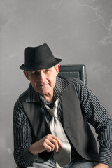 elegant elderly man with clear eyes, sitting looking straight ahead