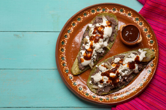 Mexican nopal cactus huaraches with cheese and beans on turquoise background