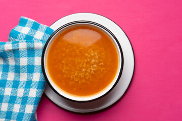 Alphabet soup pasta on pink background