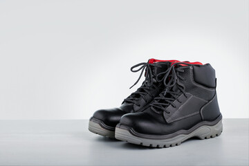 Industrial boots. Protective safety boots on grey surface. Copy space. - obrazy, fototapety, plakaty
