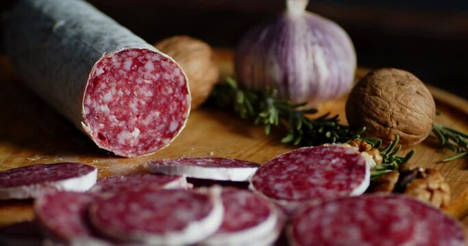 Pieces of salami with rosemary and walnuts slowly rotate.