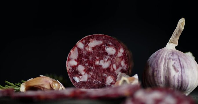 Slices of salami with garlic on the table slowly rotates.