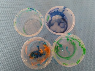 four dirty pots of colored slime
