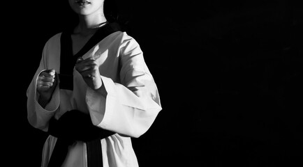 Portrait young woman taekwondo black background.