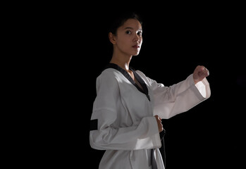 Portrait young woman taekwondo black background.