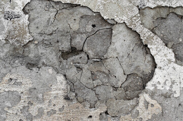 peeled off peeling scratched plaster on the surface of a concrete old wall without a large fallen off fragment for texture