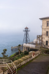 Fototapeta na wymiar Alcatraz island and prison exterior at dusk showing guard tower and fog
