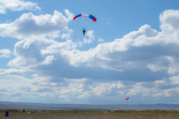 skydiver flies against the sky