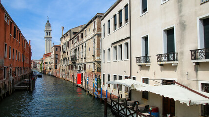 Fototapeta na wymiar Narrow canal lined with houses in Venice, Italy