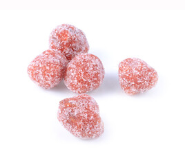 Tamarind candy, placed inside white small plate. Sweet and sour candy made from tamarind paste and coated by sugar. Natural green grass background