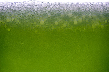 Background of close-up soda bubbles mixed with lemon juice or green juice on white background.