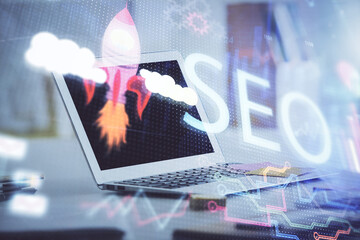 Multi exposure of table with computer and seo drawing hologram. Search optimization concept.