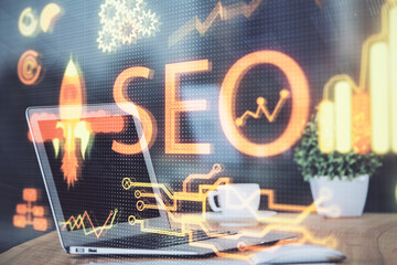 Multi exposure of table with computer and seo drawing hologram. Search optimization concept.