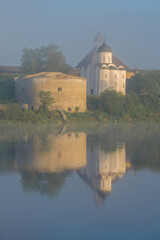 Fototapeta premium St. George Church in the Old Ladoga Fortress in the morning June fog. Leningrad region, Russia