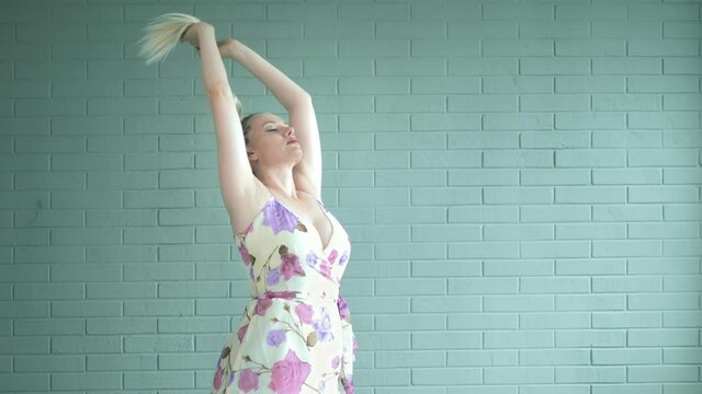 studio shot. woman with afro braids and a long ponytail against a brick wall