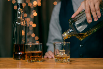 Barman pouring whiskey glass customers sit drink