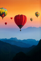 Colorful hot air balloons flying over blue mountains landscape