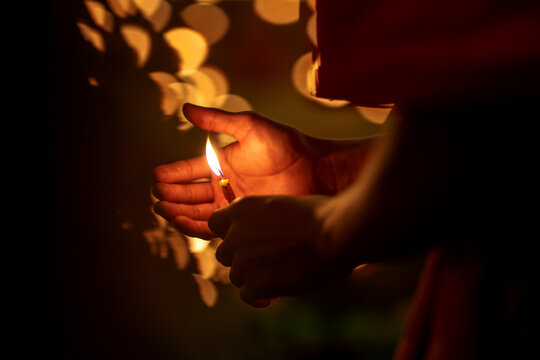 Buddhist Monk Hands Holding Candle Cup Lighting Candle  ,Chiang Mai , Thailand