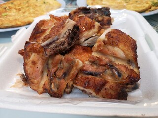Grilled chicken on a white foam dish.