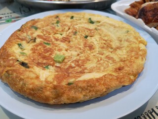 An omelette placed on a white roll.