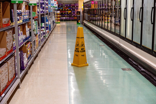 Walkerston, Queensland, Australia - February 2020: A sign warning of a wet floor in the aisle of a supermarket